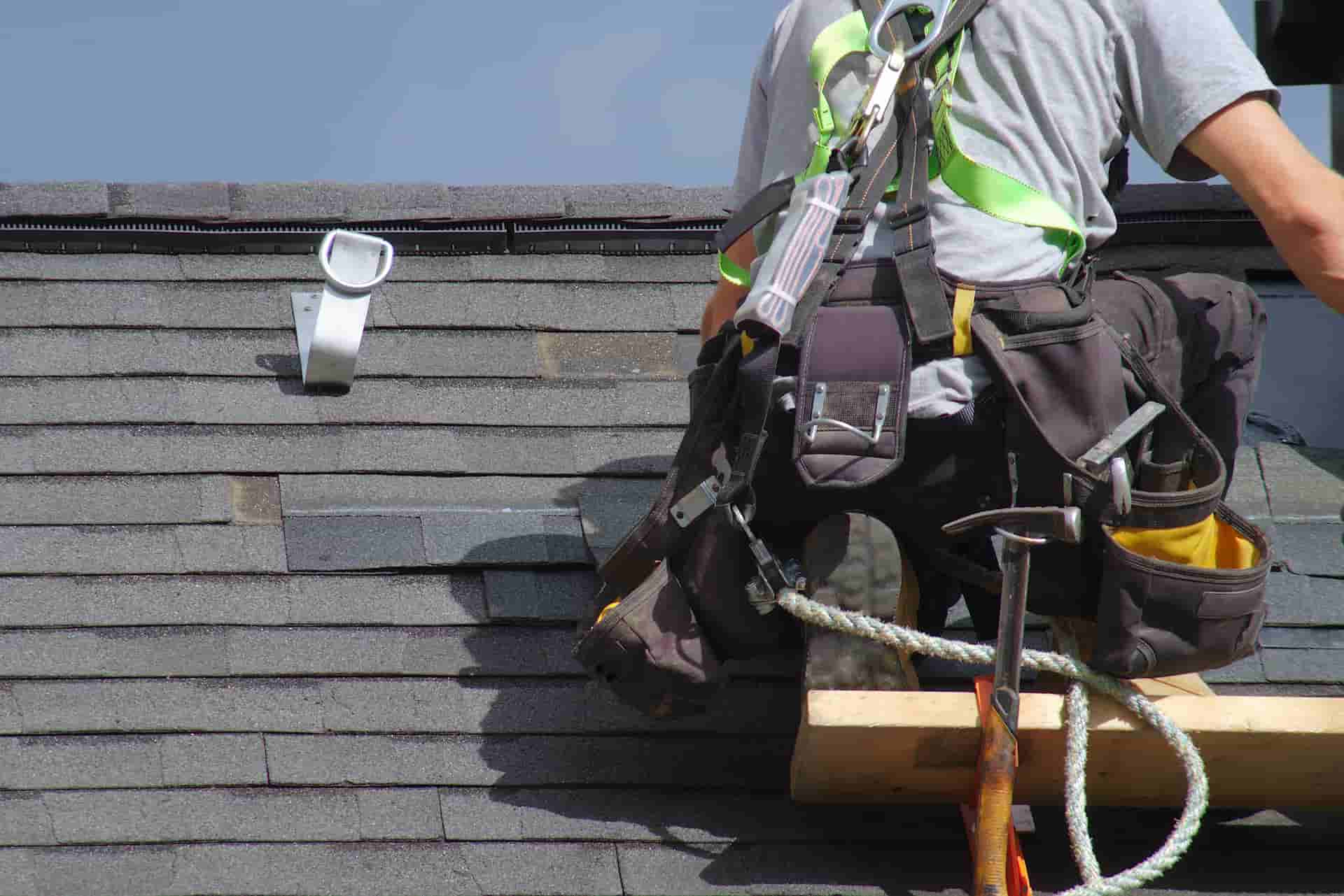 A roofing contractor working on the roof of a house.