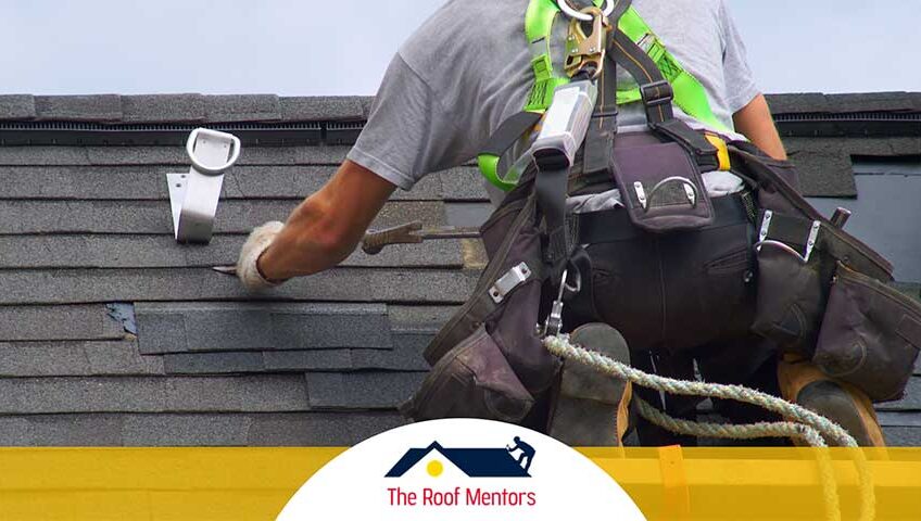 A man is fixing a shingle on a roof.