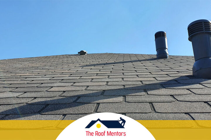 A shingled roof with a chimney in the background.